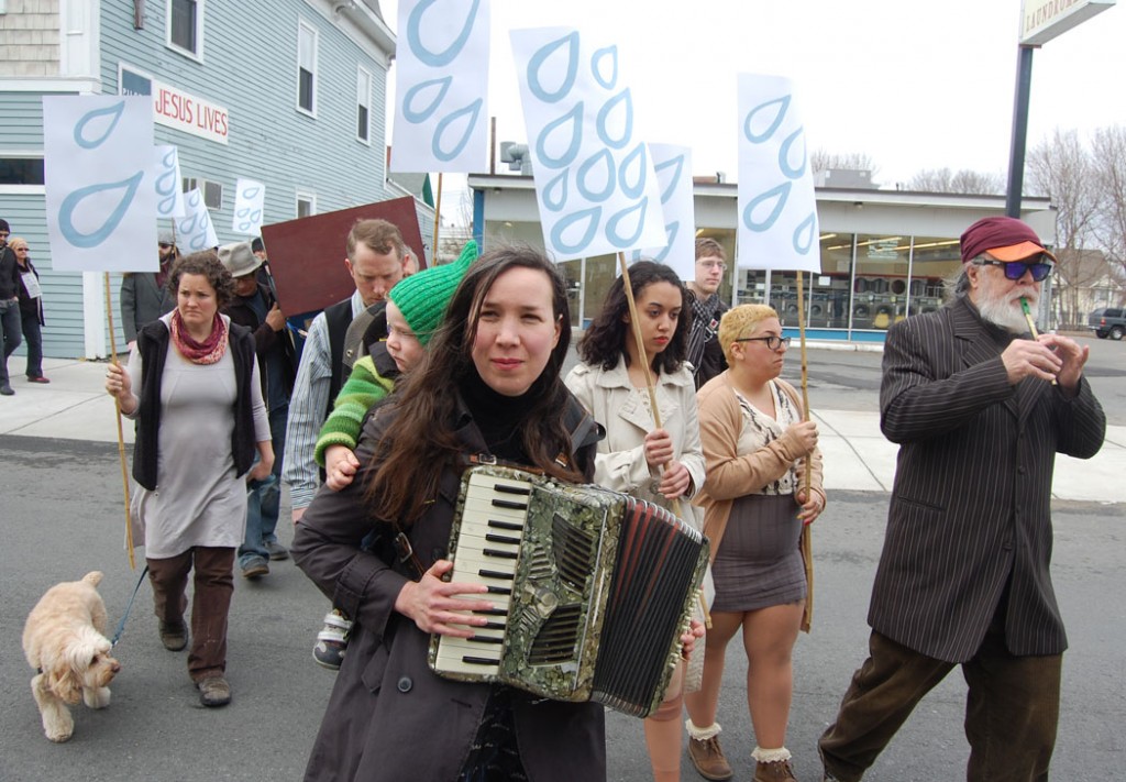Kari Percival, with son Ulysses on her back, plays accordion. Mark Dannenhauer plays flute.