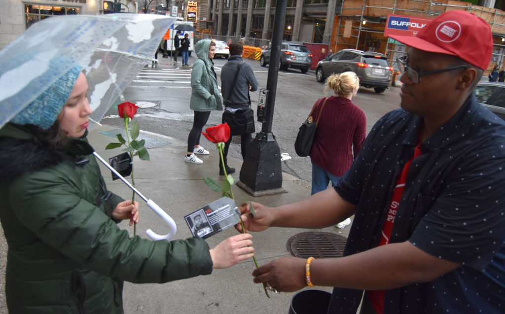 Cedric Douglas (right) handing out roses to remember more than 1,000 black people killed by police in the United States during the past five years. April 27, 2018. (Greg Cook)