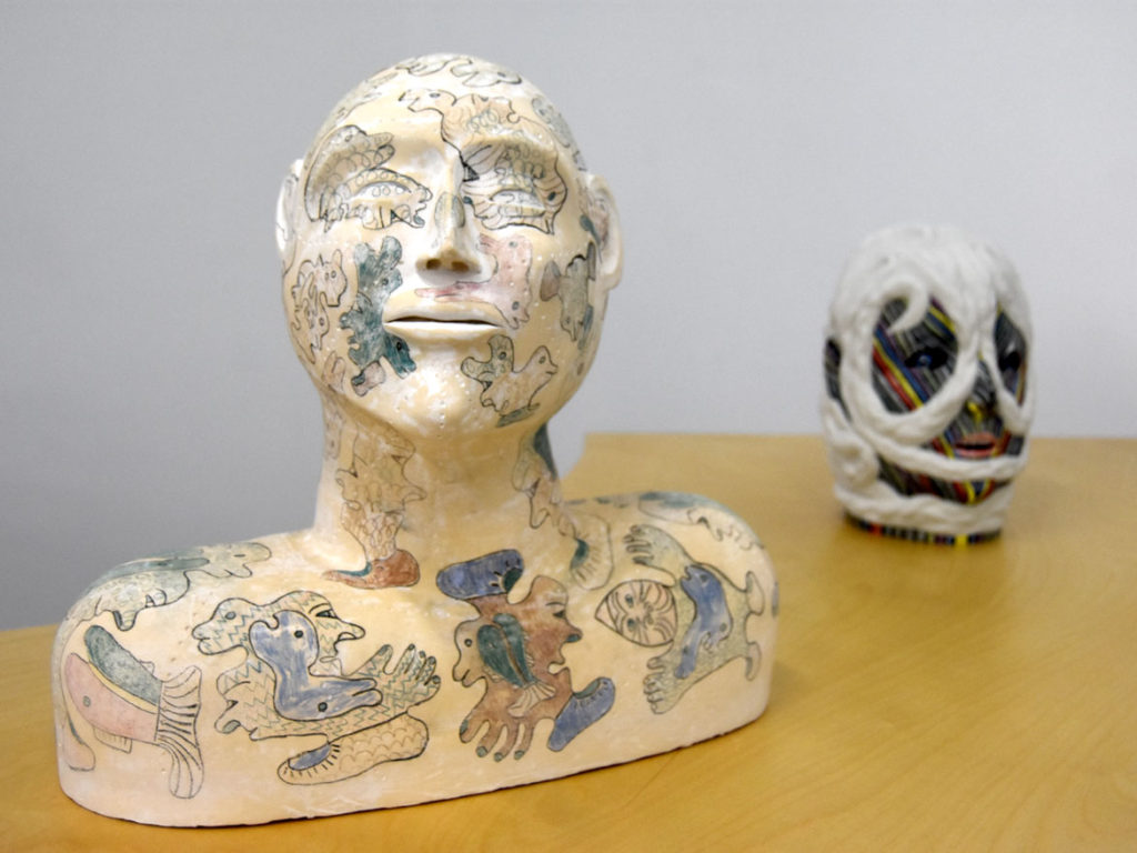 Jessie Kenalogak and John Kurok “Ceramic Bust with Drawings" (left), stoneware with unerglaze pencils.