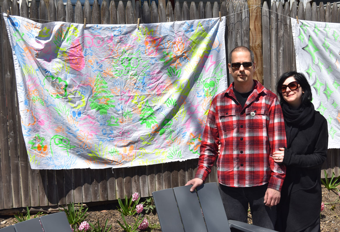 Cartoonist Ansis Purins (left) with his banner-mural (and Jennifer Aubin) at the Starting Over Festival, Somerville, April 22, 2018. (Greg Cook)