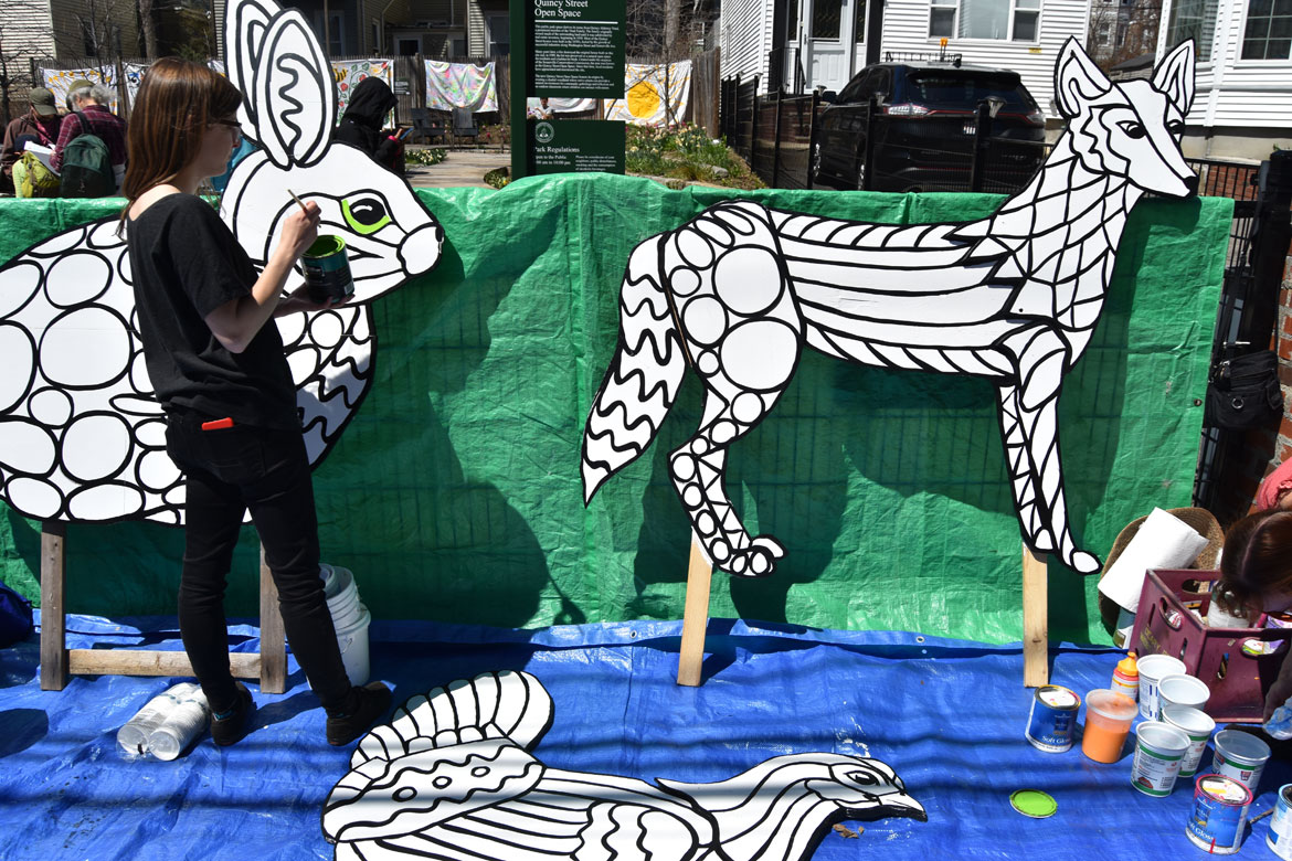 Festival co-organizer Nina Eichner helps paint mosaic-style animals designed by muralist Liz LaManche at the Starting Over Festival, Somerville, April 22, 2018. (Greg Cook)