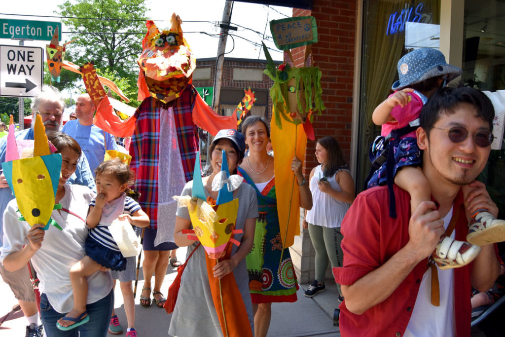Fox masks and one of the giant fox puppets, created under the leadership of Sara Peattie of the Boston Puppeteers Cooperative, at the Fox Festival Parade in Arlington, June 16, 2018. (Greg Cook)