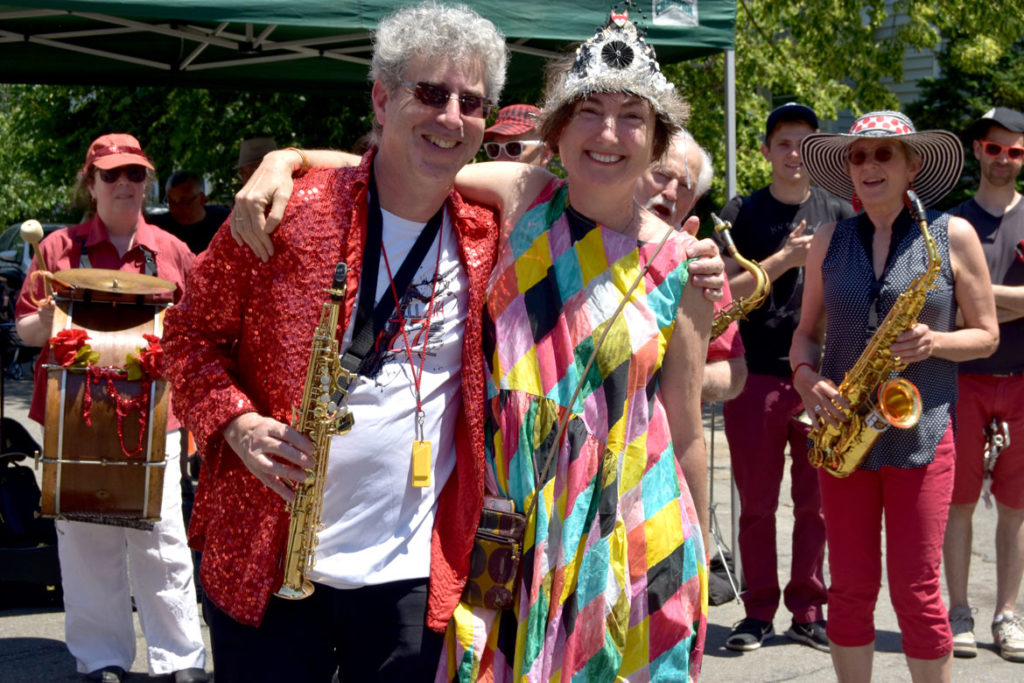 Ken Field (left) of the Second Line Social Aid & Pleasure Society Brass Band with parade organizer, Cecily Miller of Arlington Public Art, at the Fox Festival Parade in Arlington, June 16, 2018. (Greg Cook)
