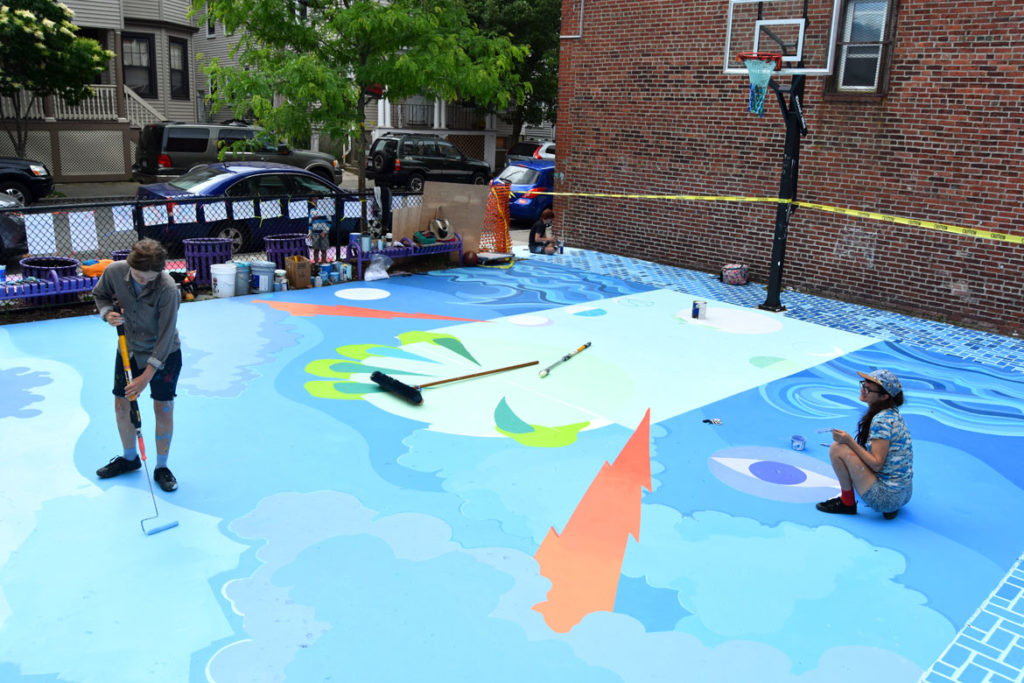 Jena Tegeler (left) Maria Molteni and Kristine Roan (background) paint the “Storming the Court” mural in Salem, June 13, 2018. (Greg Cook)