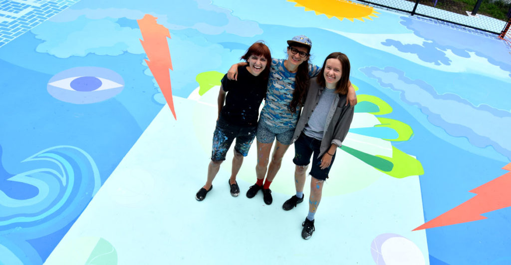 Kristine Roan (from left), Maria Molteni and Jena Tegeler at the “Storming the Court” mural (in progress) in Salem, June 13, 2018. (Greg Cook)