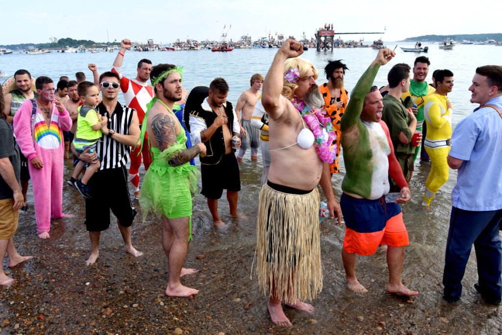 Costumed Greasy Pole contestants wait on Pavilion Beach to be ferried out to the platform (in the distance) for the contest, June 30, 2018. (Greg Cook)