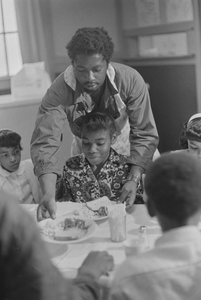 Ruth-Marion Baruch, "Charles Bursey serving children at Black Panther Free Breakfast for Children Program, St. Augustine's Episcopal Church," May 19, 1969. (Courtesy University of California, Santa Cruz)