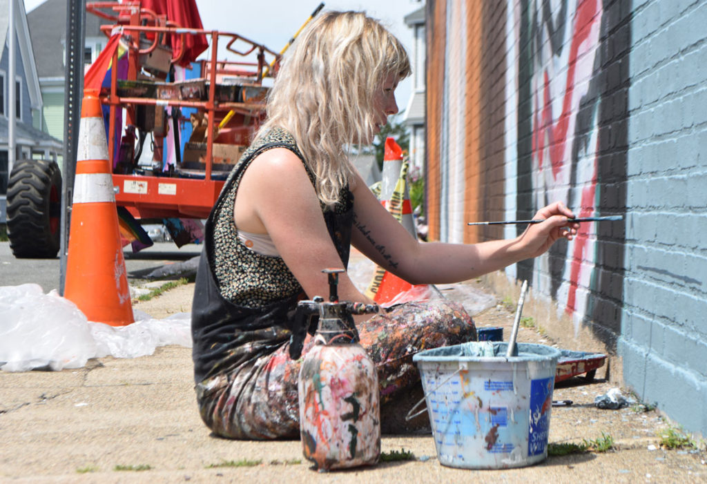 Helen Bur finishes painting her mural on the Cabot Theatre, Beverly, Massachusetts, July 20, 2019. (Greg Cook)