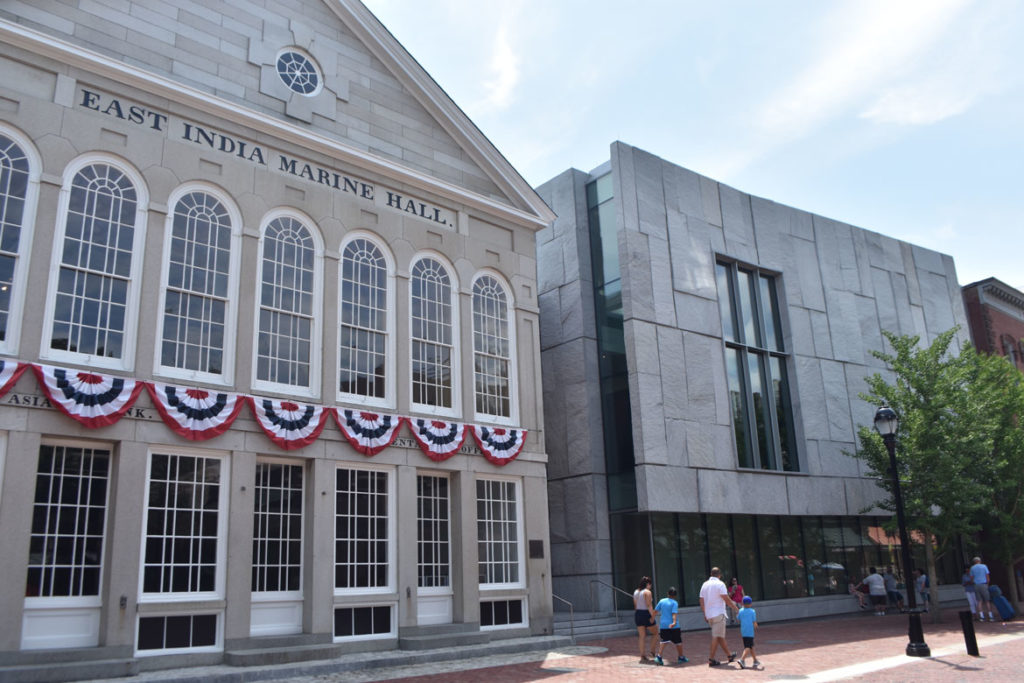 The Peabody Essex Museum's new wing (at right) designed by the New York firm Ennead Architects sits beside the East India Marine Hall on Salem's Essex Street, July 20, 2019. (Greg Cook photo)