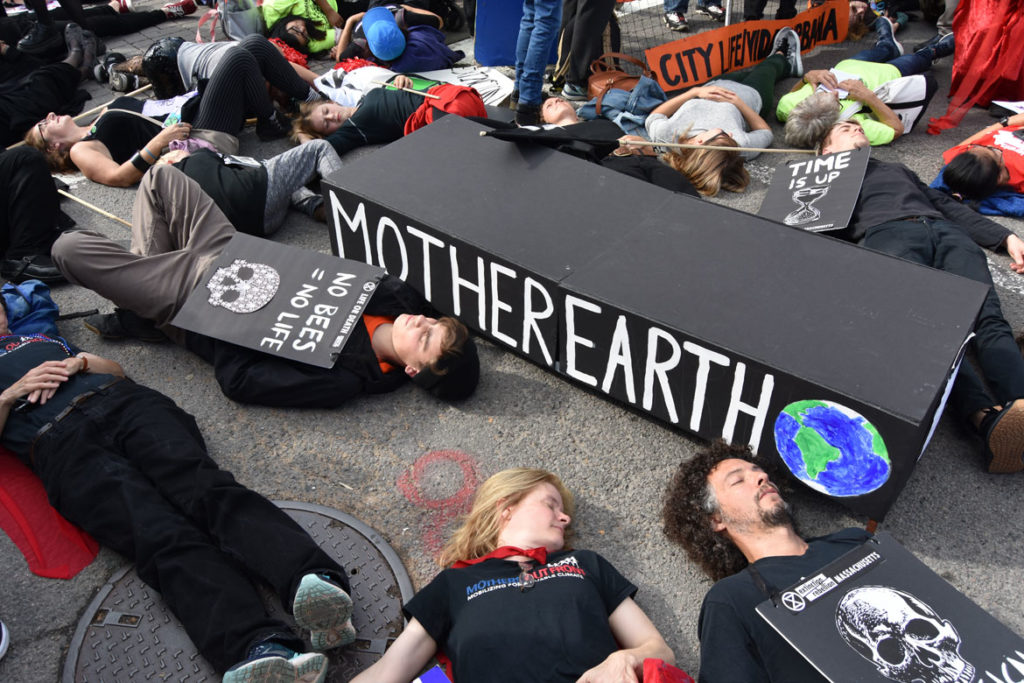 Extinction Rebellion die-in against global warming at Harvard Square, Cambridge, during in the Honk Parade, Oct. 13, 2019. (Greg Cook photo)