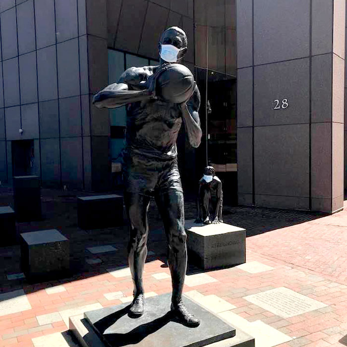 A protective mask has appeared on the 2013 statute of Boston Celtics star Bill Russell by by Ann Hirsch on Boston City Hall Plaza, c. April 6, 2020. (Courtesy)