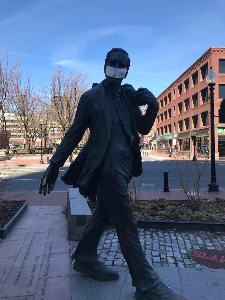 A protective mask has appeared on the statue of former Boston mayor Kevin White at Faneuil Hall, c. April 6, 2020. (Courtesy)