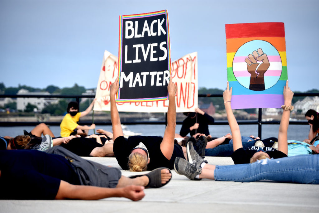 Protesters lay in silence on the ground for 8 minutes and 46 seconds in memory of George Floyd during the "Independence Day March" against injustice organized by Demilitarize Gloucester, July 4, 2020. (© Greg Cook photo)