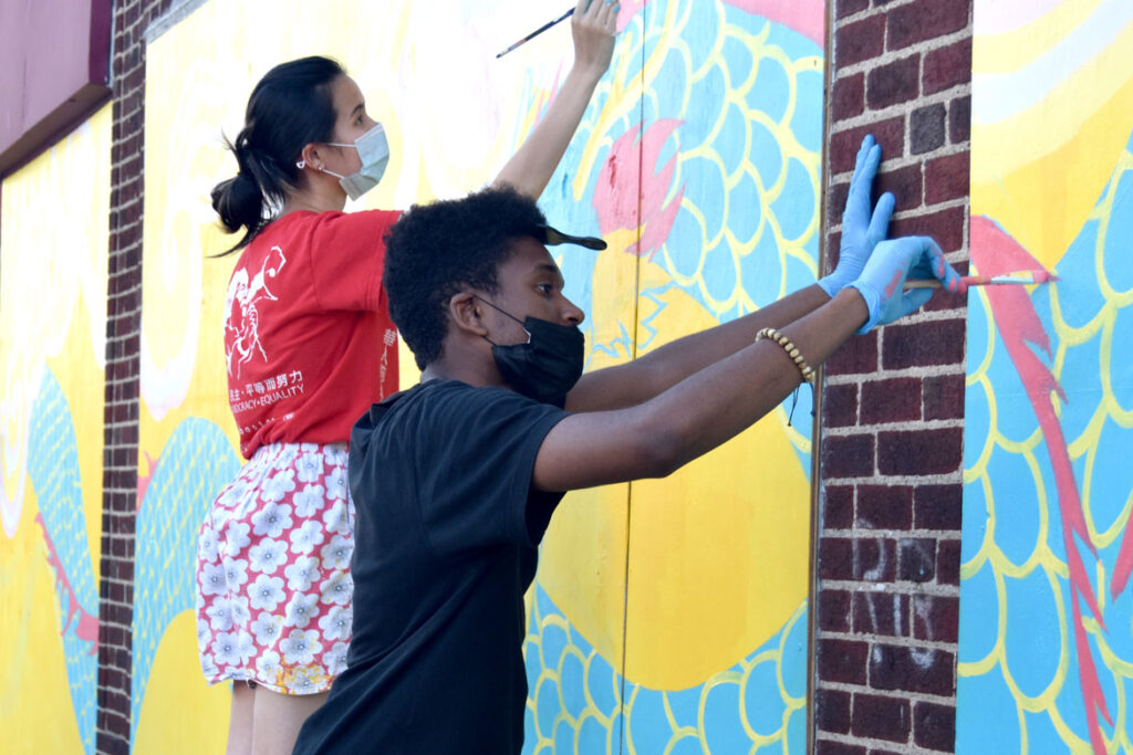 Jameson Francois (foreground) and Shaina Lu painting mural at Wah Lum Kung Fu & Thai Chi Academy in Malden, July 25, 2020. (Photo ©Greg Cook)
