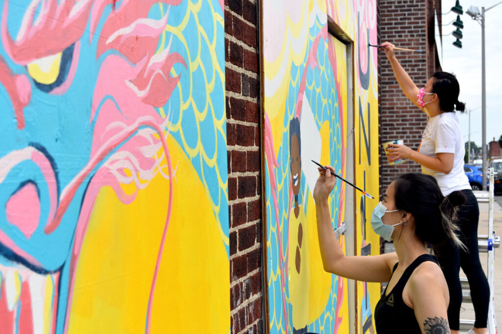 Shaina Lu (foreground) and Rayna Lo painting mural at Wah Lum Kung Fu & Thai Chi Academy in Malden, Aug. 8, 2020. (Photo ©Greg Cook)