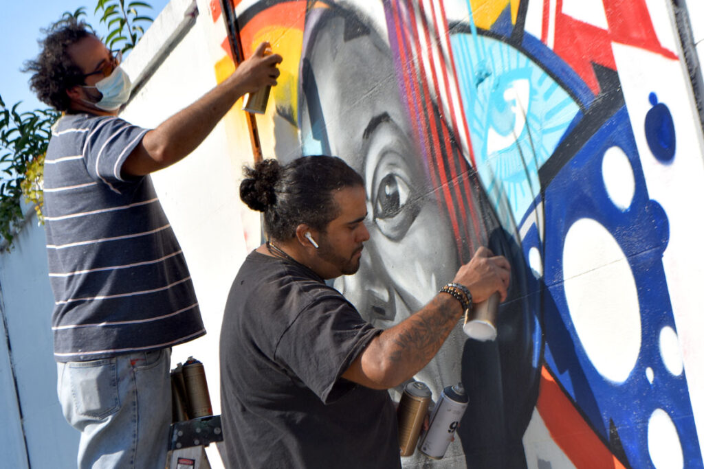 Luis "Take1" Taforo (left) and Genaro "GoFive" Ortega paint a mural of singer Nina Simone at Salem's Punto Urban Art Museum, Oct. 11, 2020. (©Greg Cook photo)