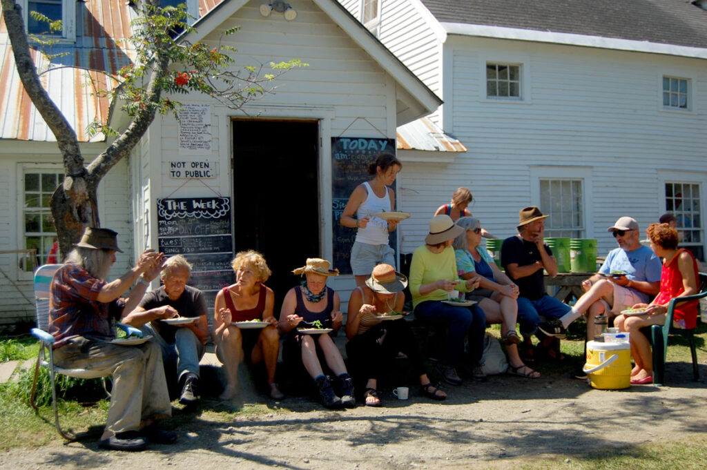 Remi Paillard (second from left) lunches with his partner Genevieve (right of him), Peter Schumann (left) and other puppeteers at the Bread and Puppet farm on a performance Sunday, Glover, Vermont, Aug. 22, 2015. (©Greg Cook photo)