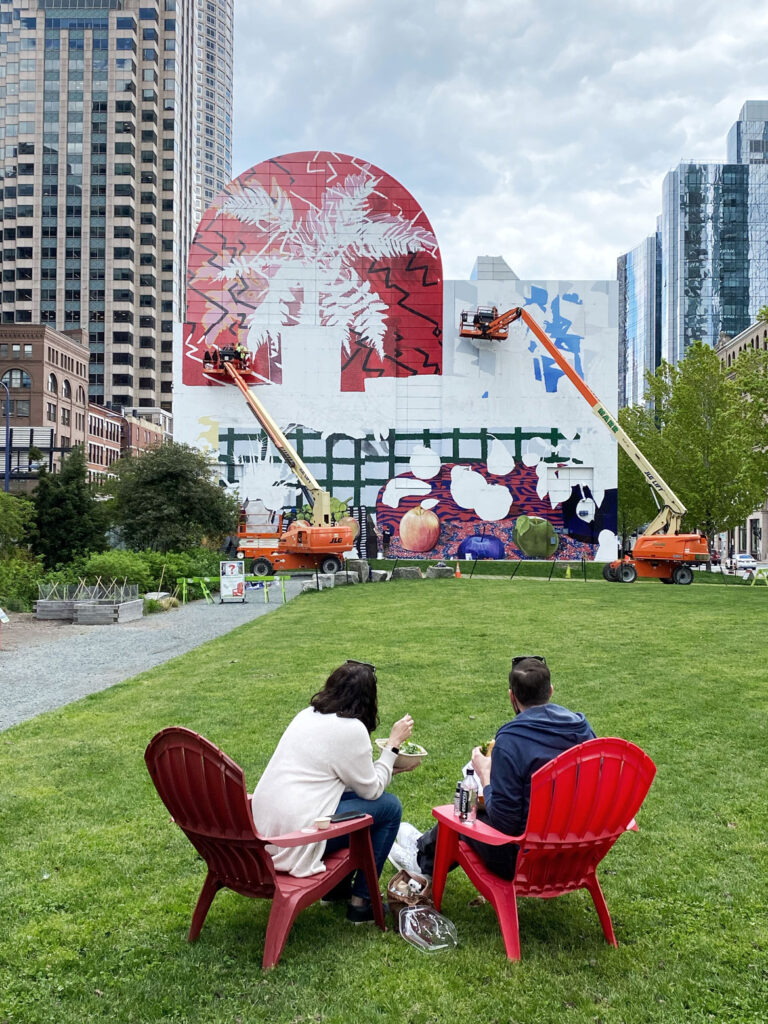 The commercial painting firm Overall Murals works on “Summer Still Life with Lobster and Fern,” designed by New York artist Daniel Gordon, on the tunnel ventilation building facing Dewey Square, along Purchase Street between Congress Street and Summer Street, May 2021. (Rose Kennedy Greenway Conservancy)
