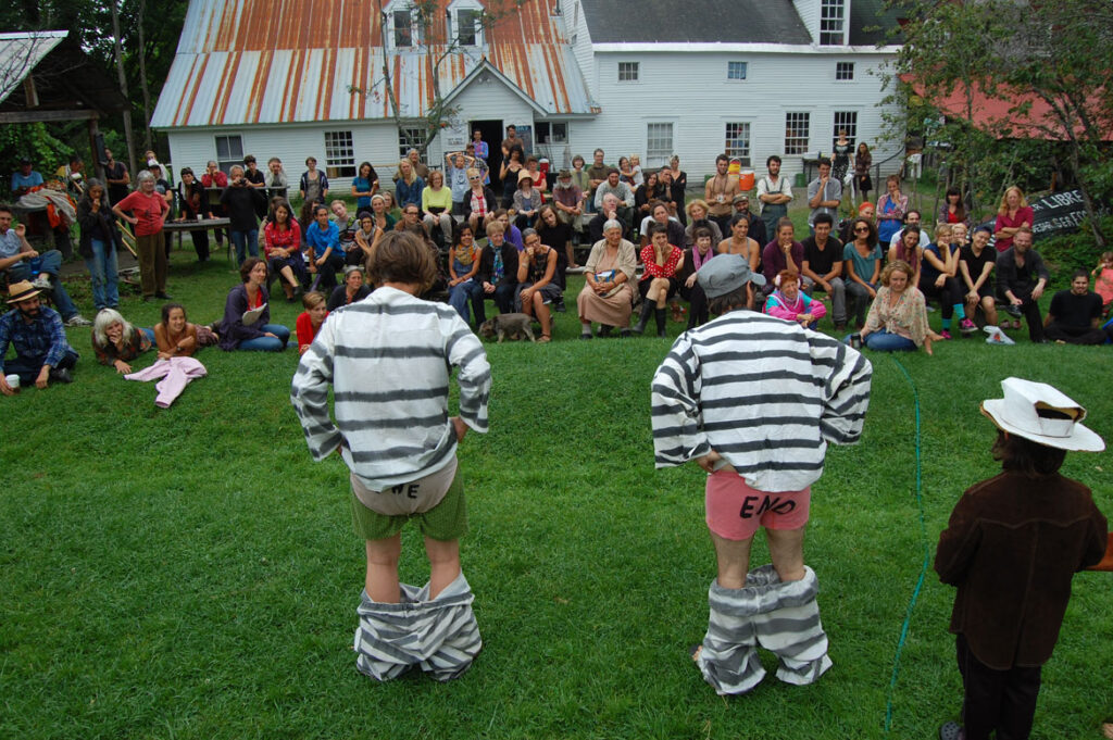 Elka Schumann (seated in front row, center) watches a circus rehearsal at Bread and Puppet, Glover, Vermont, Aug. 21 2015. (©Greg Cook photo)
