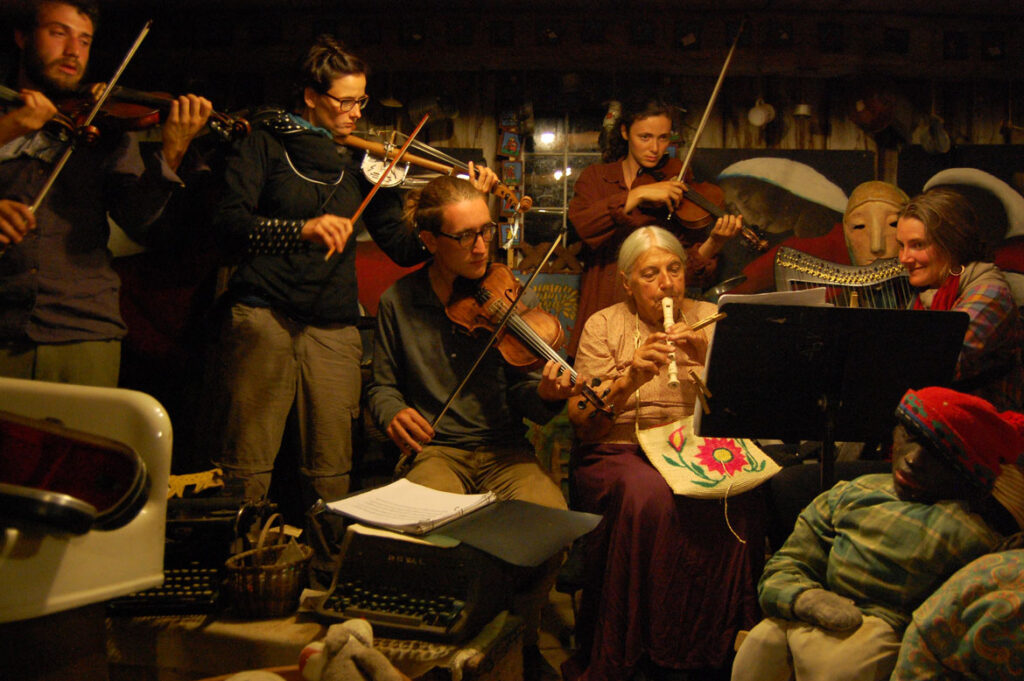 Elka Schumann (seated at center) plays recoder in the Bread and Puppet Museum, Glover, Vermont, Aug. 22 2015. (©Greg Cook photo)