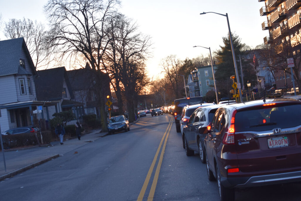 Traffic backed up along Salem Street waiting for free covid rapid test kits distribution at Malden's Salemwood School, Jan. 4, 2022. (©Greg Cook photo)