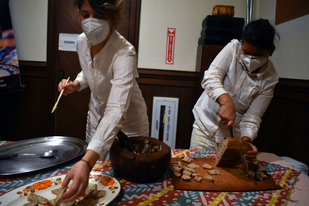 Serving bread and aoli after Bread and Puppet Theater performed "Finished Waiting" at First Church in Cambridge, March 22, 2022. (©Greg Cook photo)