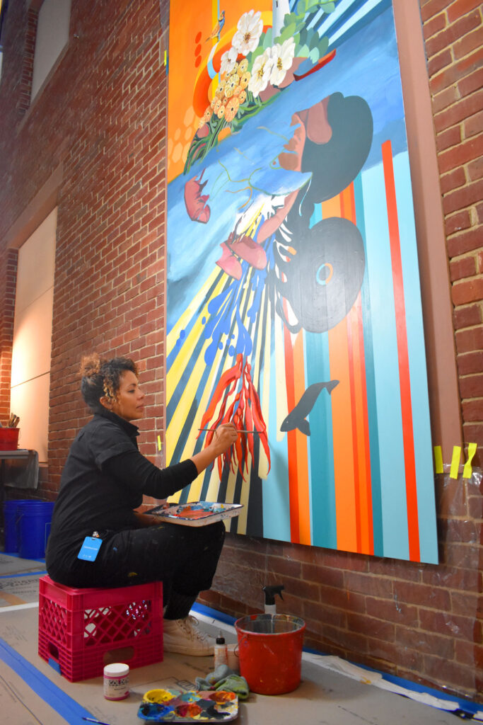 Silvia Lopez Chavez paints "Undercurrent" at the Peabody Essex Museum, March 12, 2022. It will be part of the exhibition "Climate Action: Inspiring Change," which is due to open at the Salem museum on April 16, 2022. (©Greg Cook photo)