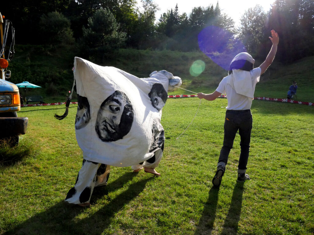Bread and Puppet Theater rehearses an act critiquing poor treatment of farm workers. Part of its "Apocalypse Defiance Circus" in Glover, Vermont, Aug. 27, 2022. (© Greg Cook photo)
