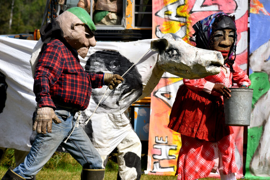 Bread and Puppet Theater performs an act critiquing poor treatment of farm workers. Part of its "Apocalypse Defiance Circus" in Glover, Vermont, Aug. 28, 2022. (© Greg Cook photo)