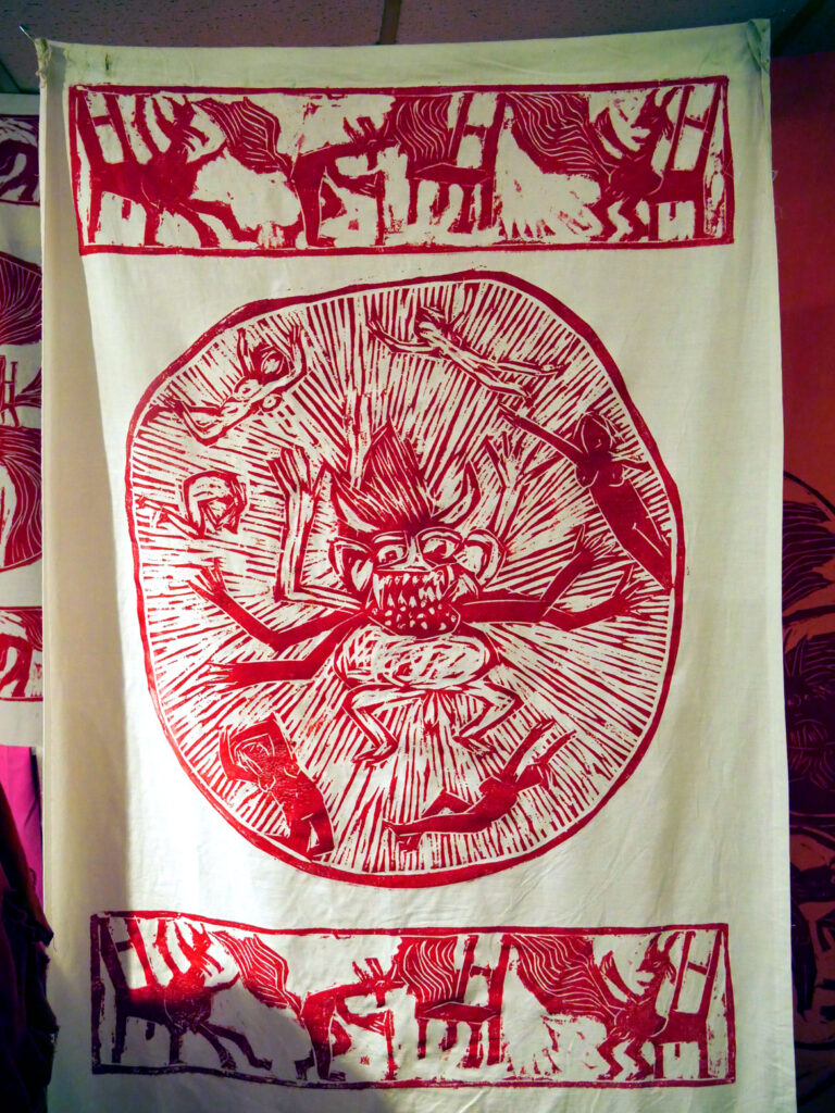 Woodcut banner from the 1971 performance “The Birdcatcher in Hell” in the exhibition “Bread and Puppet Theater: Art and Activism in Five Acts” at Salem State University, November 2022. (©Greg Cook photo)