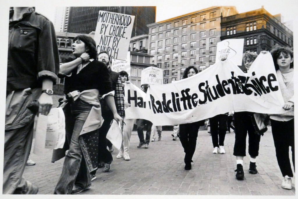 Radcliffe students donstrating at Boston's Government Center for pro-choice abortion laws, reproduction of photo by Debbie Rich, 1985. "Witness for the Unborn," pro-life march, Boston, c 1975. In "The Age of Roe: The Past, Present, and Future of Abortion in America" at Harvard Radcliffe Institute Schlesinger Library's Poorvu Gallery.