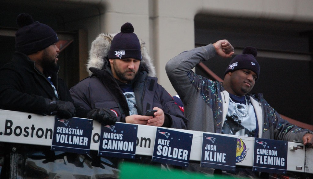 Marcus Cannon (from left), Sebastian Vollmer and Cameron Fleming roll past City Hall Plaza. (Greg Cook)