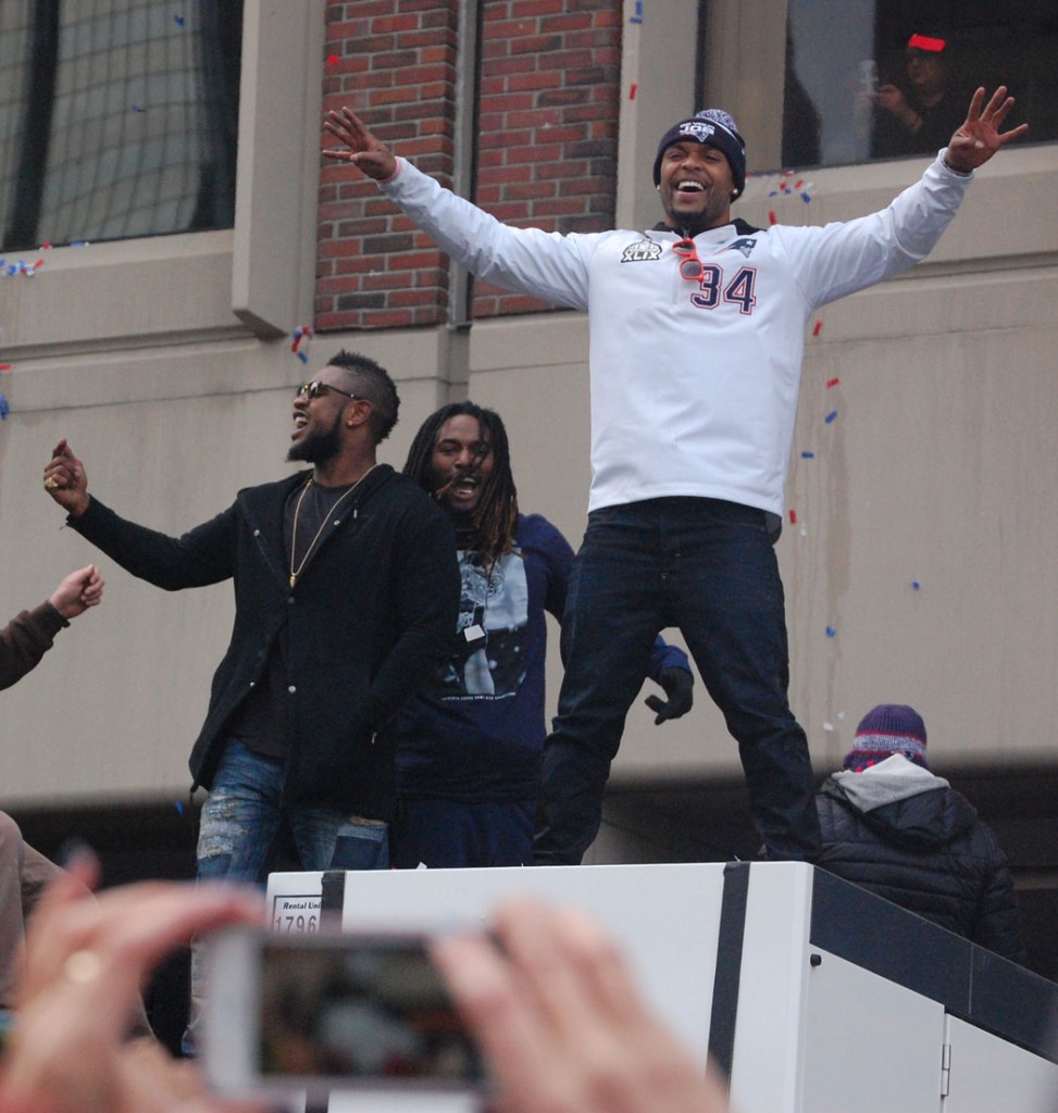 Steven Ridley (from left), Brandon Bolden and Shane Vereen celebrate as they roll past City Hall Plaza. (Greg Cook)