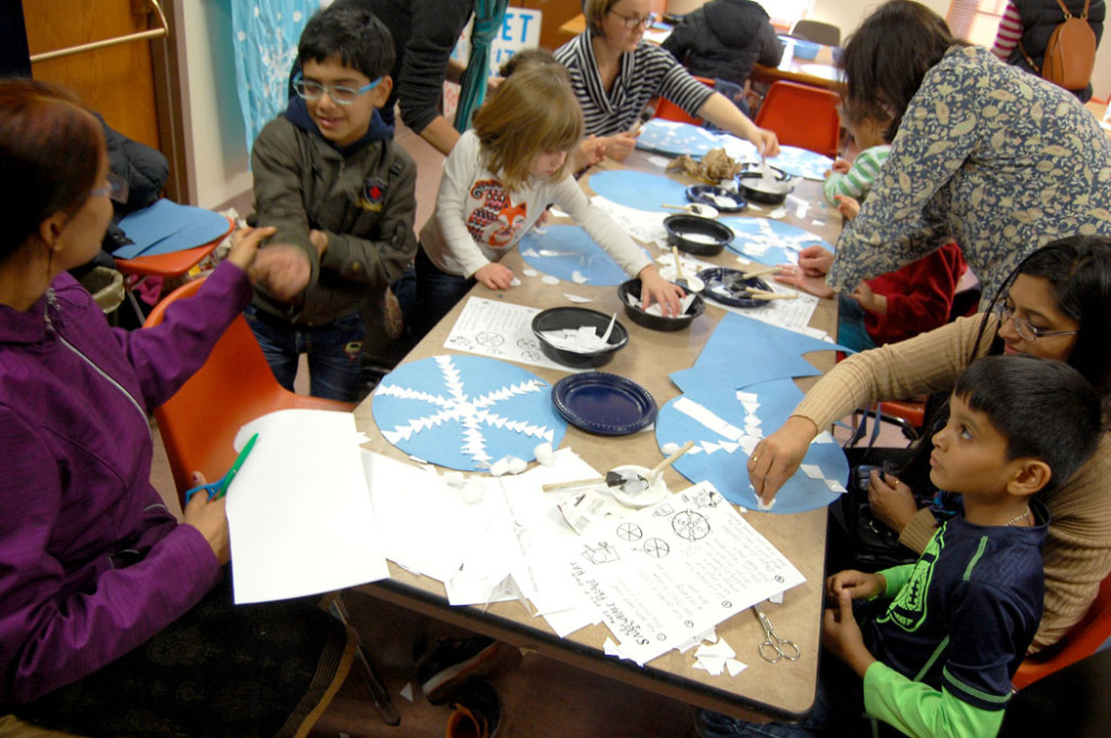 Making snowflake hat at the Malden Public Library for the “Let It Snow! Santas Against Global Warming!” parade group, Saturday, Nov. 19, 2016. (Greg Cook)