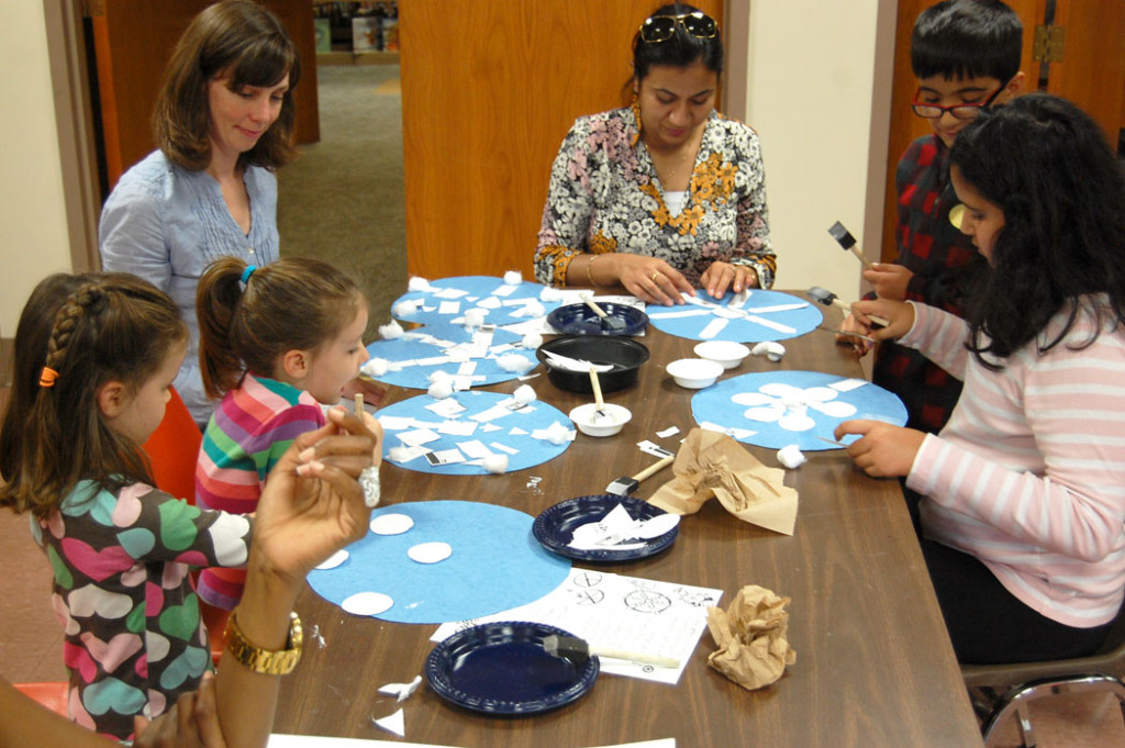 Making snowflake hat at the Malden Public Library for the “Let It Snow! Santas Against Global Warming!” parade group, Saturday, Nov. 19, 2016. (Greg Cook)