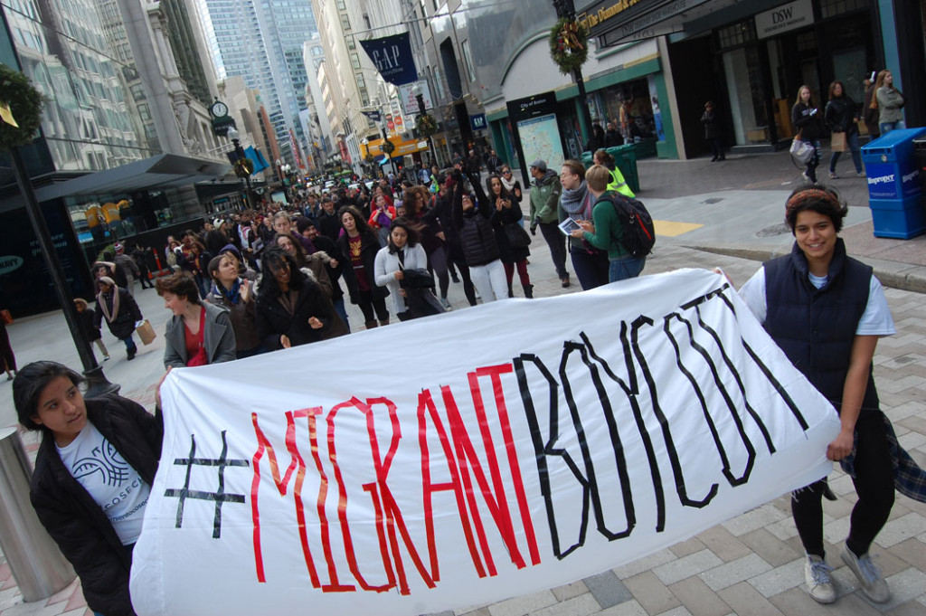 Immigrant rights protesters march between Primark and T.J. Maxx. (Greg Cook)