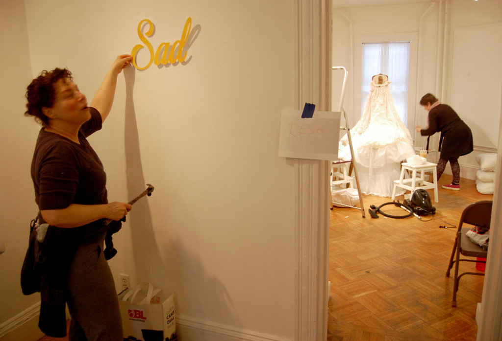 Resa Blatman (left) nails up her text and fake flowers installation while Samantha Fields prepares her installation in the next room. (Greg Cook)