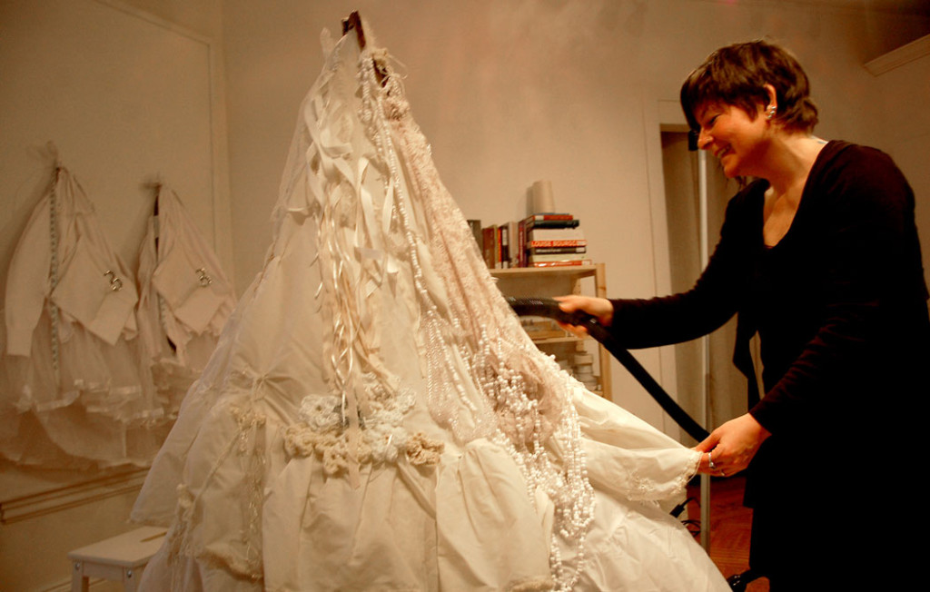 Samantha Fields steams a petticoat in preparation for performances in her installation. (Greg Cook)