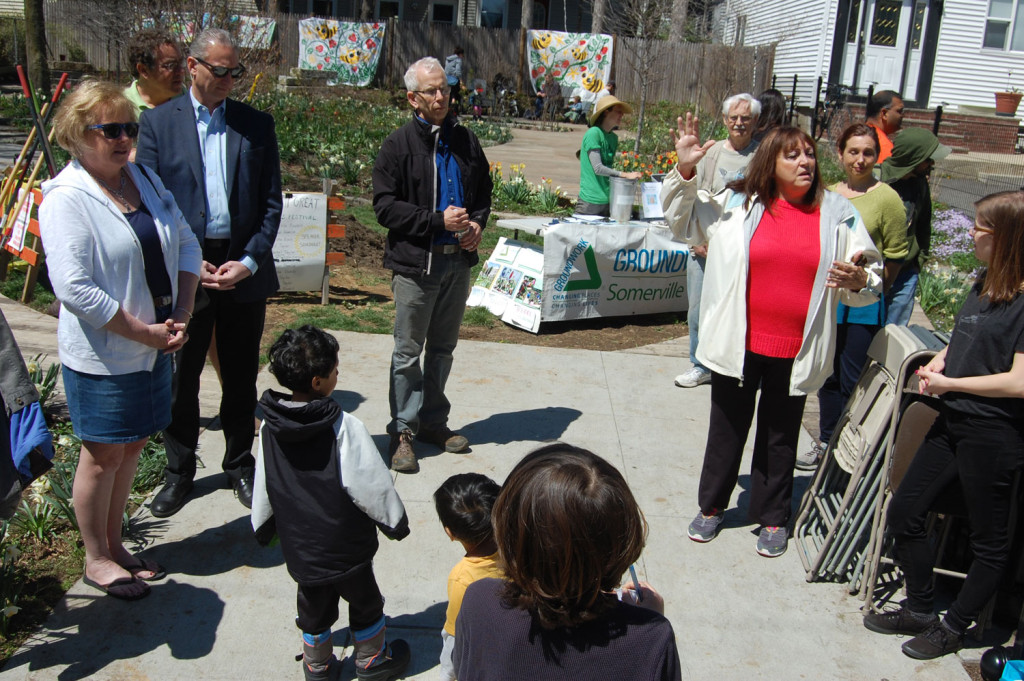 Alderman Maryann Heuston (at right in red) speaks about how the Quincy Street Open Space was developed. Listening are (from left) Alderman Mary Jo Rossetti, Somerville Arts Council Executive Director Greg Jenkins, Alderman Bob McWatters, Somerville Parks Director Arn Franzen, Bryan Hamlin, Sasha Vivelo, and Somerville Arts Council Special Events Manager Nina Eichner. (Greg Cook)