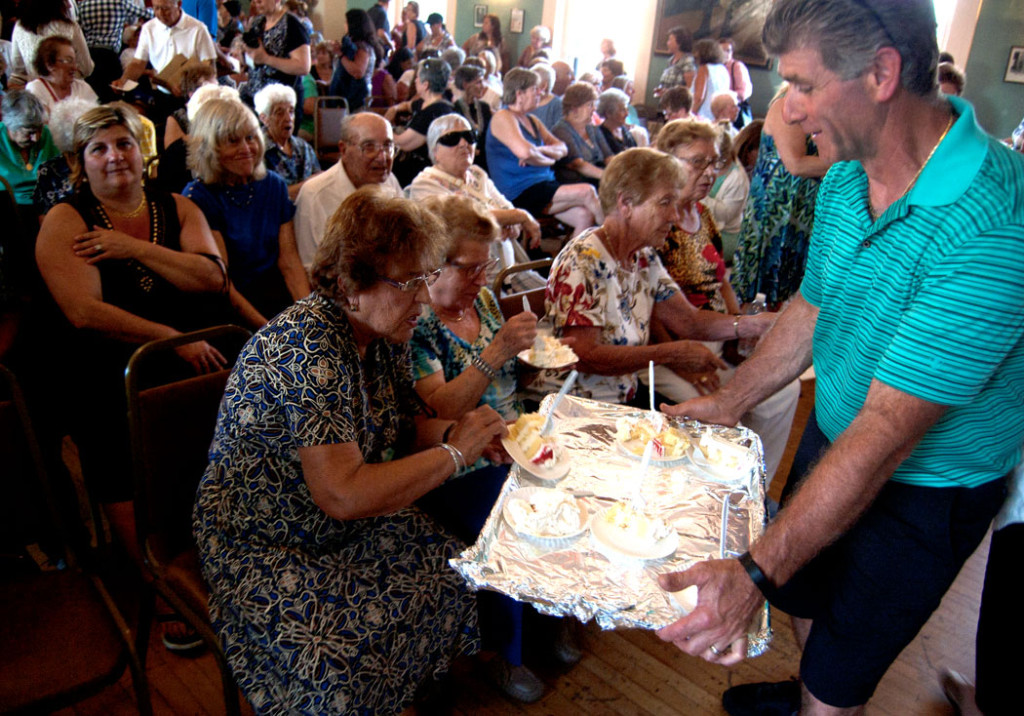 Passing out cake at the end of the St. Peter's Fiesta Novena Mass in Gloucester, June 20, 2017. (Greg Cook)