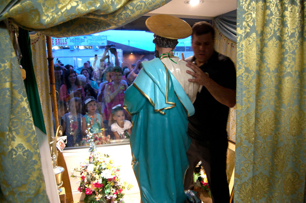 Returning the St. Peter statue to his window in the St. Peter's Club on Rogers Street at the end of the procession, June 20, 2017. (Greg Cook)