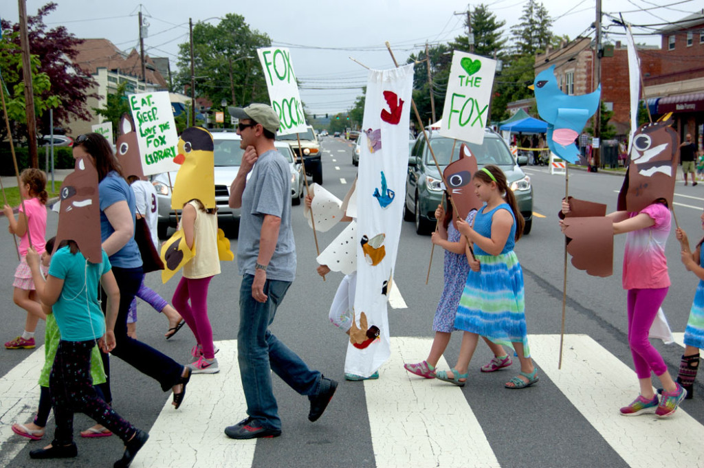 Kids wear masks and carry signs they made with Kari Percival during the Fox Festival Parade in Arlington, June 17, 2017. (Greg Cook)