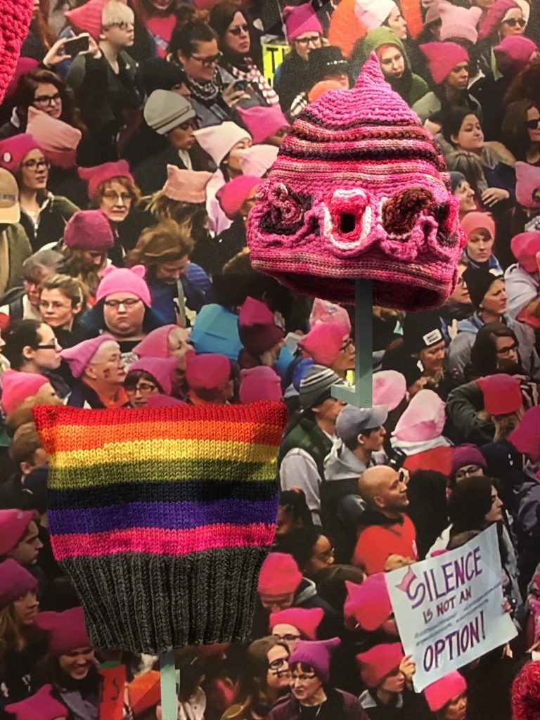Pussyhats by Hila Happy Knits (left) and Fedora Jacobson. (Courtesy of Fuller Craft Museum)