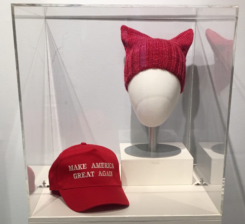 MAGA hat (left) and test knit hat for the pussycat pattern, donated by Stefanie Kamerman of the Pussycat Project. (Courtesy of Fuller Craft Museum)