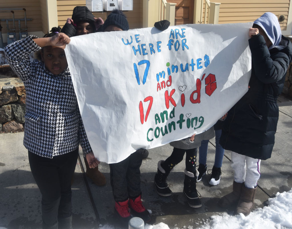 "We are here for 17 minutes and 17 kids and counting." Elementary students from Cambridgeport School protest guns on Broadway in Cambridge, March 15, 2018. (Greg Cook)