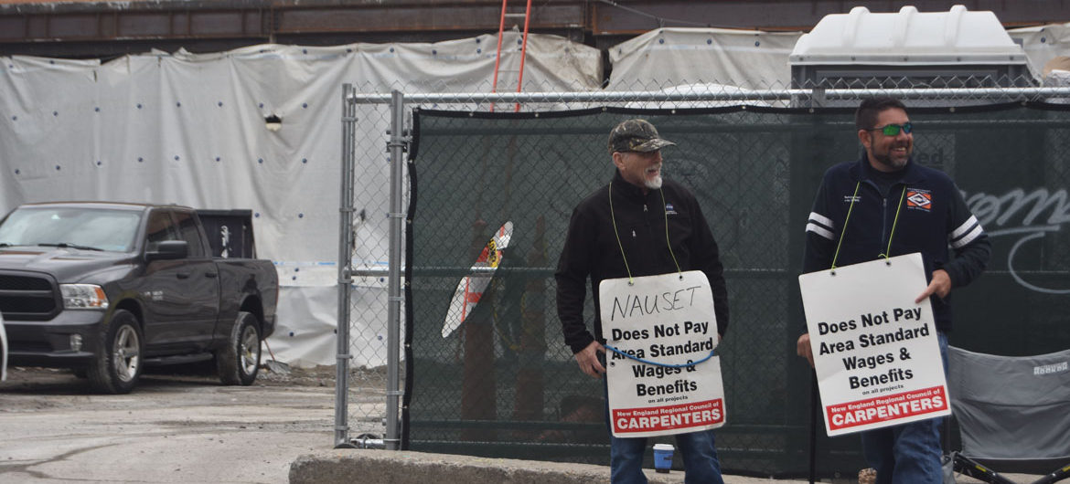 Carpenters union members protest a Nauset Construction retail and apartment project at 10 Essex St. in Cambridge's Central Square, April 13, 2018. (Greg Cook)