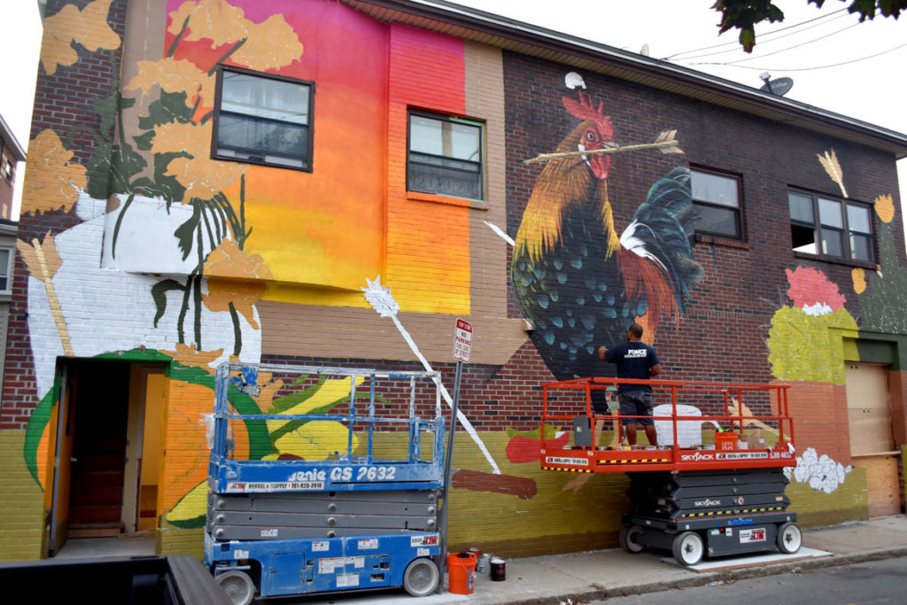 David Zayas paints his mural at 44 Broadway, Somerville, Aug. 27, 2018. (Greg Cook)