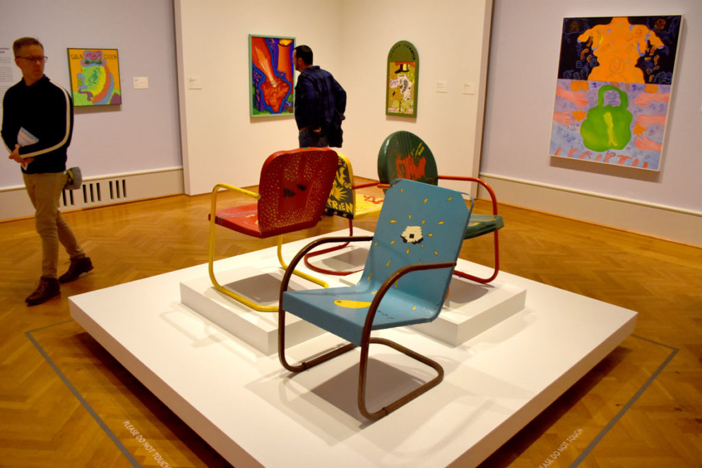 Metal lawn chairs painted by Jim Nutt and Karl Wirsum with paintings by (from left) Wirsum, Art Green, Nutt and Suellen Rocca in “Hairy Who? 1966–1969” at the Art Institute of Chicago. (Greg Cook)