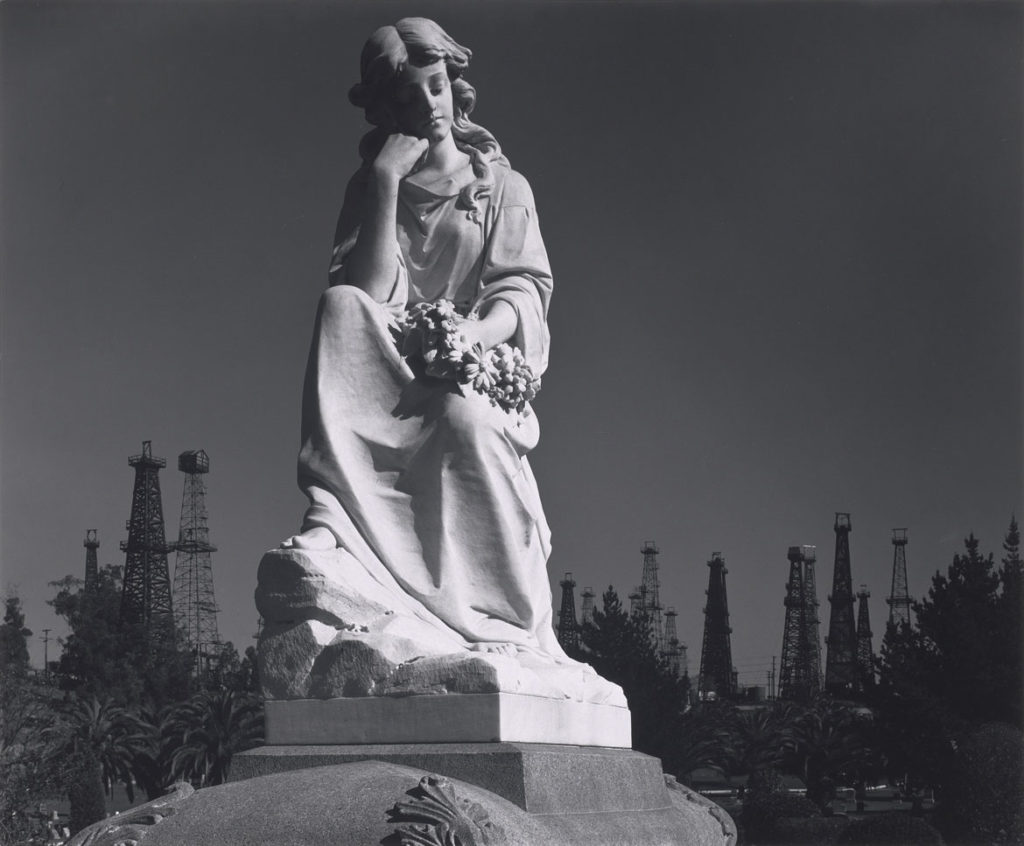 Ansel Adams, "Cemetery Statue and Oil Derricks, Long Beach, California," 1939, photograph, gelatin silver print. (Courtesy, Museum of Fine Arts, Boston)