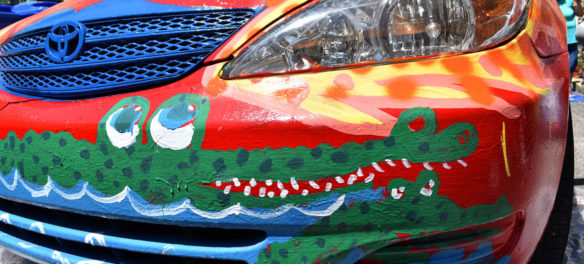 Painting Mark Alston-Follansbee's Toyota Camry art car in the driveway of his Waltham home, July 7, 2019. (Greg Cook)